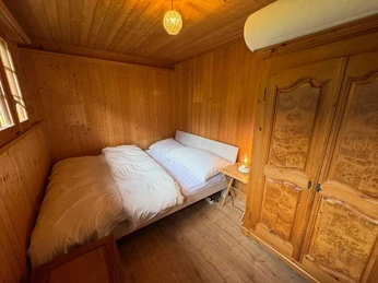 Small bedroom with double bed Kleines, holzgetäfertes Schlafzimmer mit Bett und HolzschrankSmall, wood-paneled bedroom with bed and wooden wardrobePetite chambre à coucher avec boiseries, lit et armoire en bois