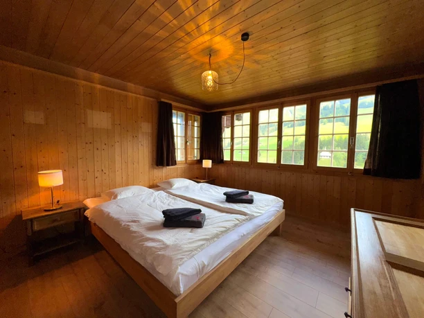 Master bedroom Double bed with white bed linen in wood-paneled room