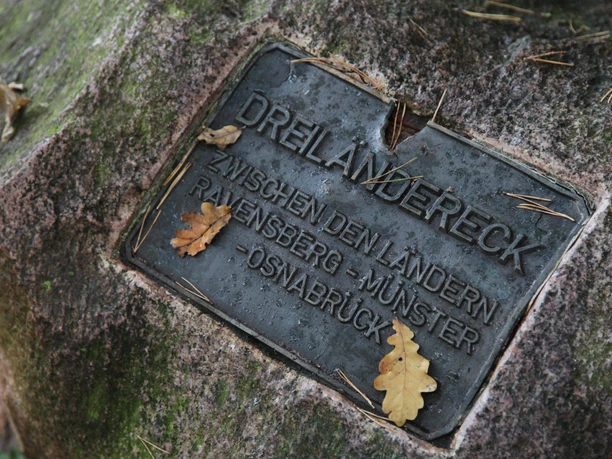 IMG_0039.JPG Plakette auf einem Stein beim Dreiländereck Osnabrück. Eichenblätter liegen verstreut auf der Plakette.