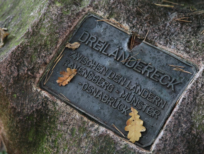 IMG_0039.JPG Plakette auf einem Stein beim Dreiländereck Osnabrück. Eichenblätter liegen verstreut auf der Plakette.
