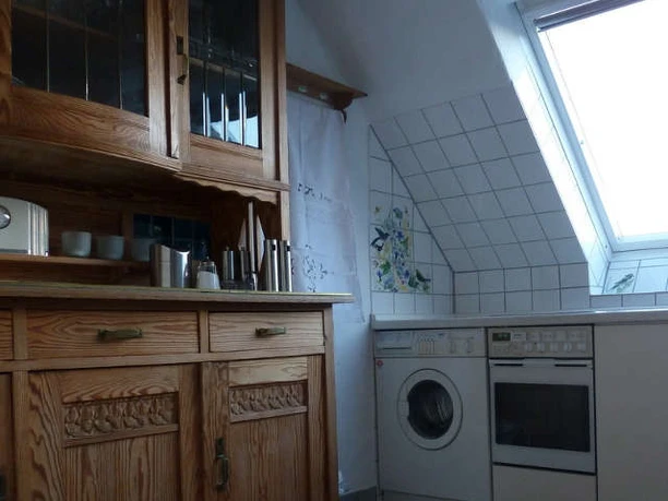 P1070270-800x600_Bei-Veronica_2.jpg Kleine Küche mit Holzschrank, modernen Geräten und Dachfenster, das natürliches Licht hereinlässt.