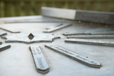 Stadt_Borgholzhausen_Urheber-immer-mit-angeben-direkt-am-Bild (12).jpg Metallplatte mit Richtungsschildern auf einem Aussichtspunkt, zeigt Entfernungen zu nahegelegenen Zielen.