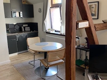 Kleine Küchenzeile mit rundem Esstisch und zwei Freischwingerstühlen