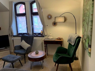 Sitzecke mit zwei Sesseln und antiken Tischchen
