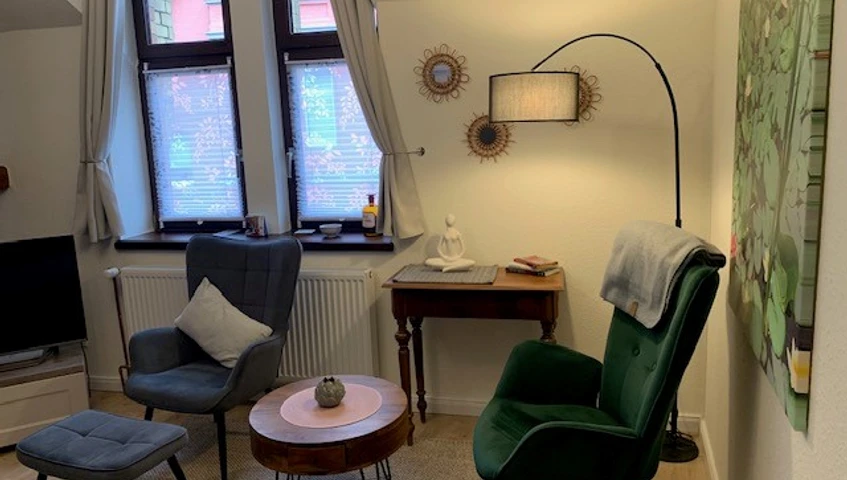 Sitzecke mit zwei Sesseln und antiken Tischchen