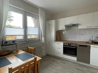 fewo_hermanns_kueche.jpg Moderne Küche mit Esstisch für vier Personen, hellen Fronten, großem Fenster und Laminatboden.