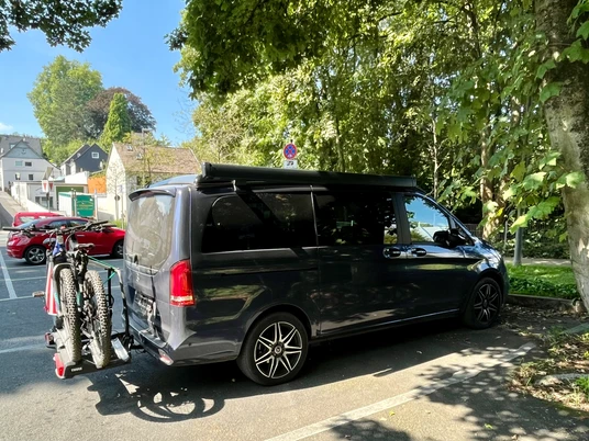 Wohnmobilstellplatz in Mettmann an der Schwarzbachstraße Wohnmobil mit Fahrradträger auf einem schattigen Stellplatz unter großen Bäumen in Mettmann.