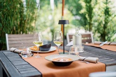 Terrasse im Bistro, Schloss Hugenpoet Ein Tisch im Bistro Schloss Hugenpoet mit eleganter Tischdekoration und Speisen im Freien.