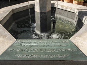 Löwenbrunnen Sechseckiger Steinbrunnen mit Wasserfluss, hebräische Inschrift auf Plakette im Vordergrund.Hexagonal stone fountain with flowing water, Hebrew inscription on plaque in the foreground.