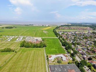 Luftansicht des Cmampingplatzes, geradeaus das Meer und rechts der Ort Hooksiel