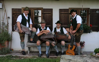 Weinberg-Zithermusi-Volkmusik-Sitzbank-Zithern.jpg Die vier Musikanten der Weinberg Zithermusi mit Instrumenten