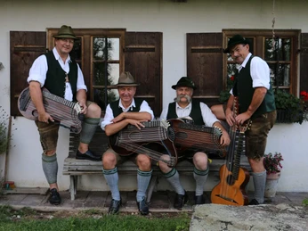 Weinberg-Zithermusi-Volkmusik-Sitzbank-Zithern.jpg Die vier Musikanten der Weinberg Zithermusi mit Instrumenten