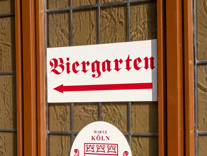 Brauhaus Schreckenskammer Ein Fenster des Brauhauses Schreckenskammer in Köln mit einem Schild, das auf den Biergarten hinweist.A window of the "Brauhaus Schreckenskammer" brewery in Cologne with a sign pointing towards the beer garden.