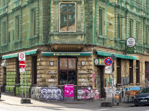 Bei Oma Kleinmann Restaurant Ansicht auf ein historisches Gebäude im urbanem Flair mit Graffiti an den Wänden.