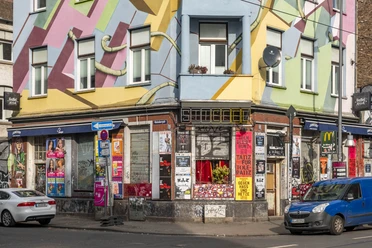 Der Stiefel Farbenfrohe Hausfassade in Köln mit urbanem Graffiti und Plakaten an den Wänden im Stadtzentrum.