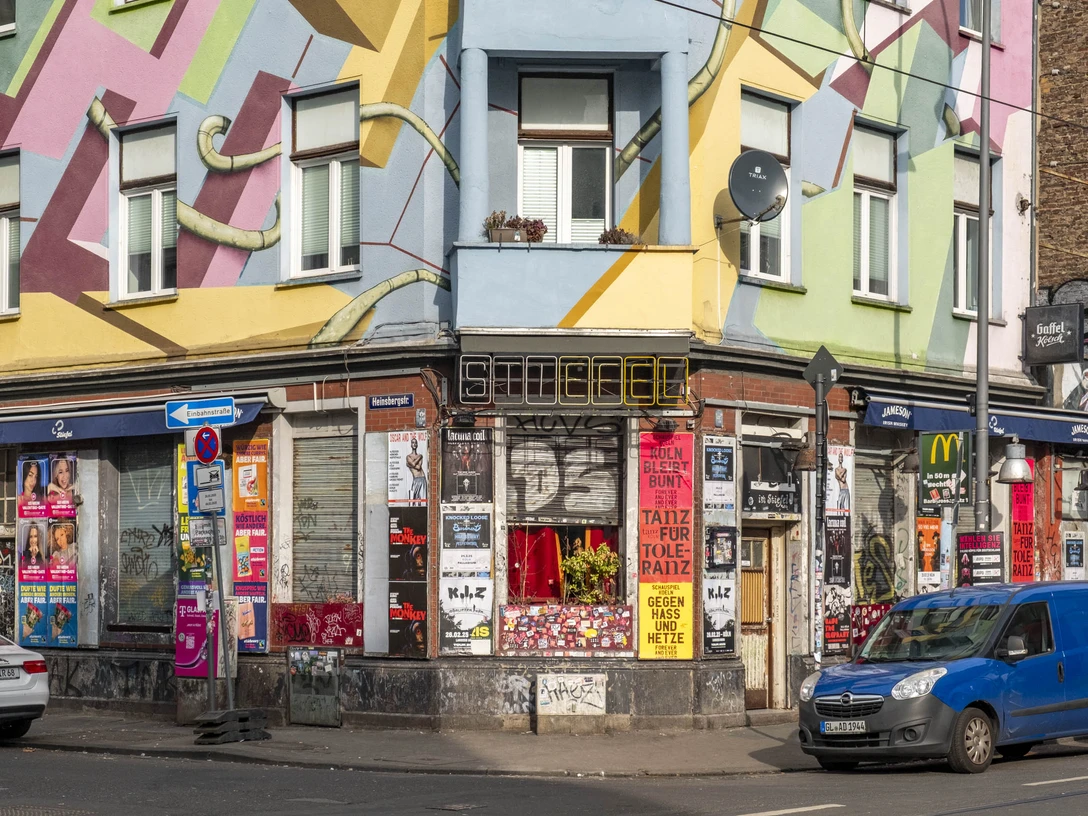 Der Stiefel Farbenfrohe Hausfassade in Köln mit urbanem Graffiti und Plakaten an den Wänden im Stadtzentrum.Colorful house facade in Cologne with urban graffiti and posters on the walls in the city center.