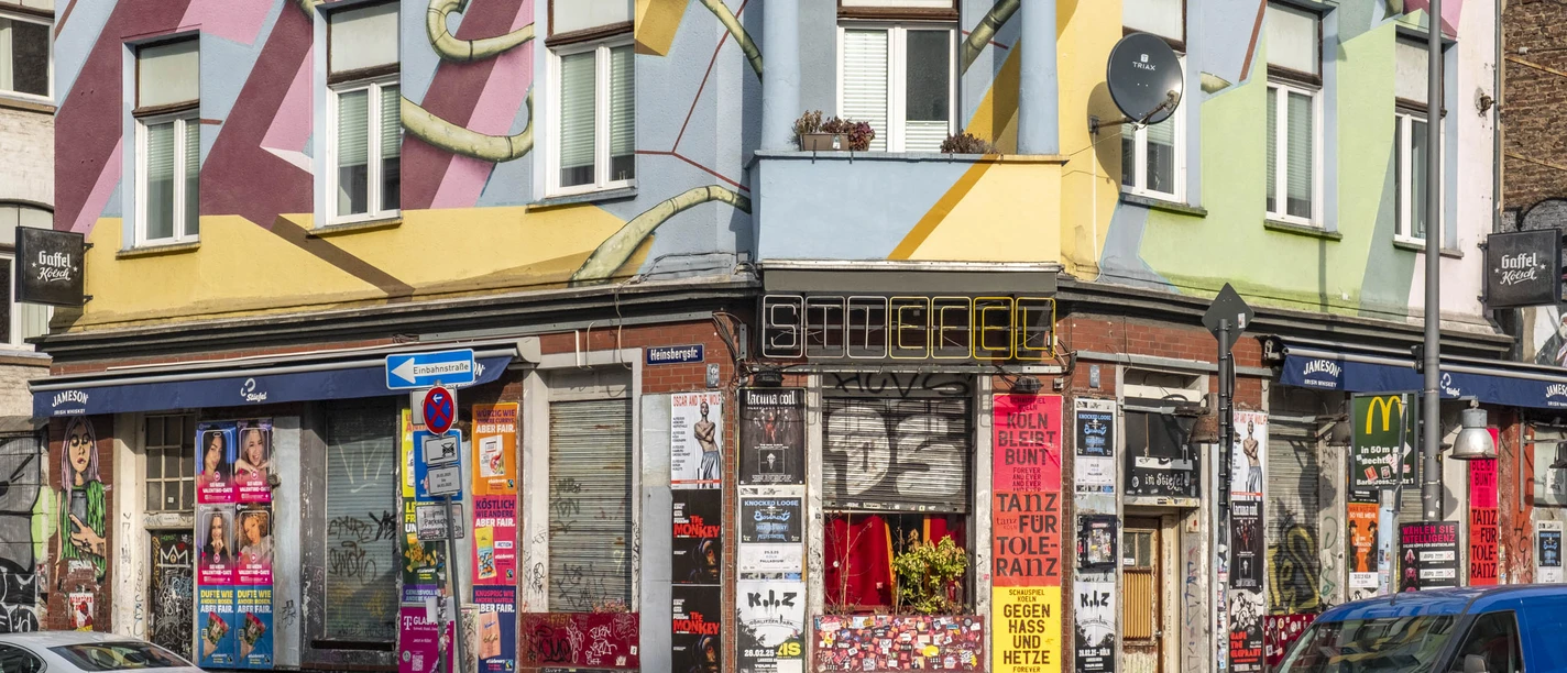 The Boot in the Latäng Quarter Colorful house facade in Cologne with urban graffiti and posters on the walls in the city center.