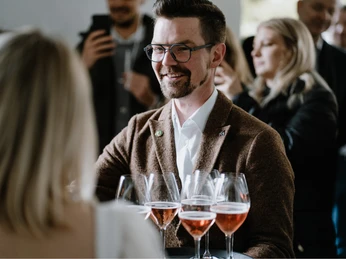 Sören Hartendorf freut sich auf Gäste bei einer Verkostung in einer eleganten Umgebung mit Weingläsern.