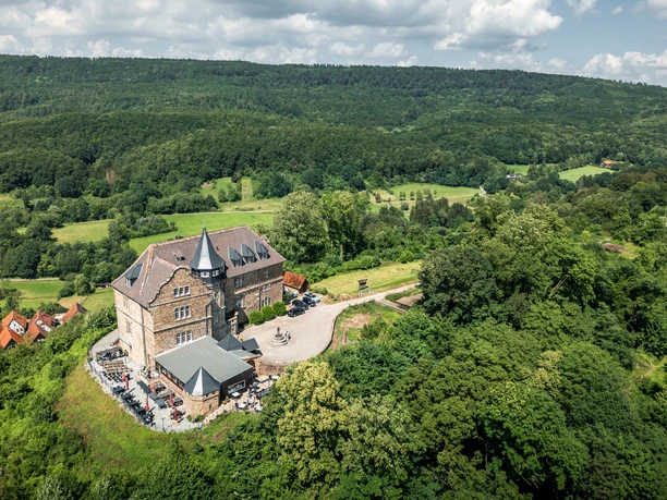 Luftaufnahme Burg Schwalenberg.jpg Luftaufnahme der Burg Schwalenberg, umgeben von Wald und Feldern mit Blick auf den grünen Horizont.