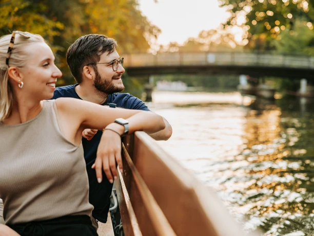 Excursion en bateau sur l'Elster blanc - Leipzig, ville d'eau Une jeune femme et un jeune homme sont assis sur un bateau à moteur du port de Leipzig au coucher du soleil et profitent d'une promenade sur la Weiße Elster, ville d'eau de Leipzig.