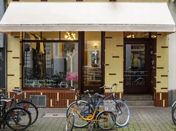 Herrenbude Die Vorderansicht eines Altbaus mit gelber Klinkerfassade und großen Fenstern. Vor dem Eingang stehen mehrere Fahrräder auf dem Gehweg.The front view of an old building with a yellow brick façade and large windows. Several bicycles are parked on the sidewalk in front of the entrance.