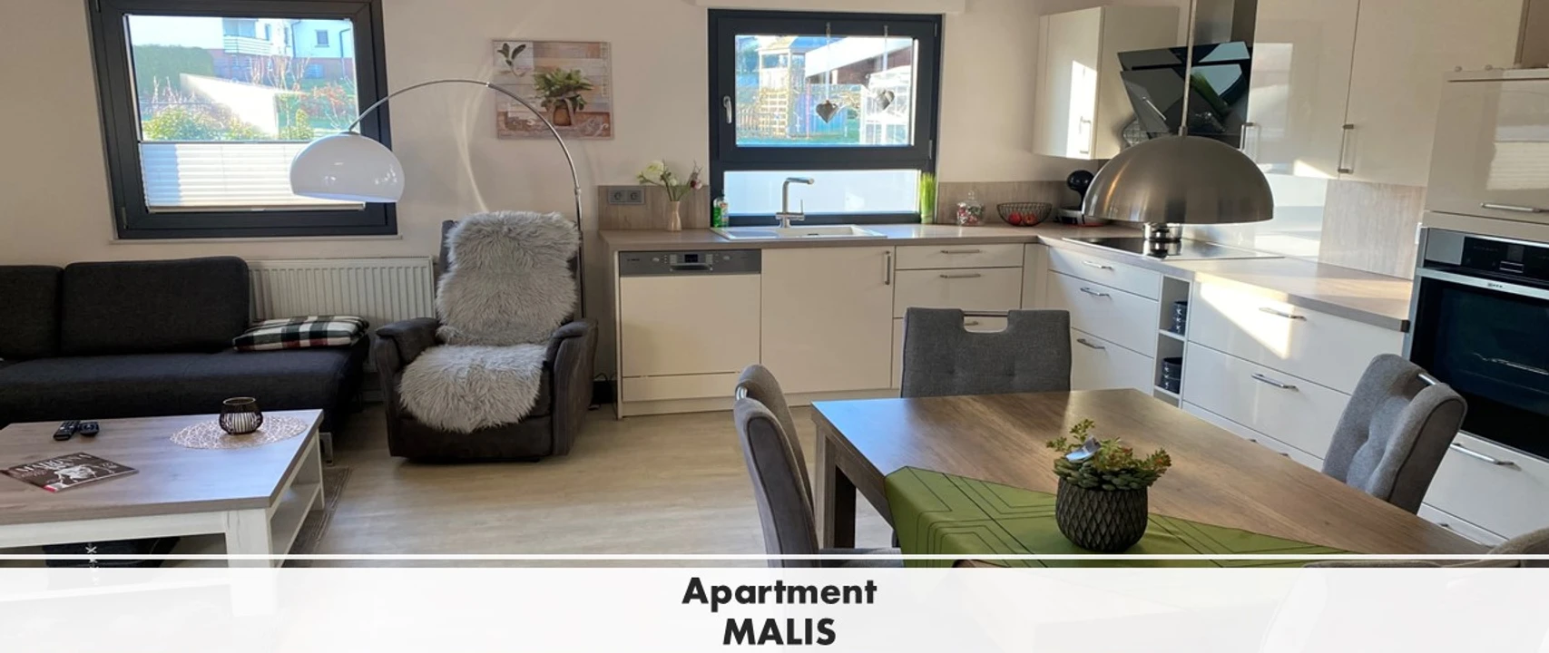 Apartment MALIS Modernes Apartment mit offenem Wohnbereich, heller Küchenzeile, Essbereich und bequemen Sitzmöbeln.