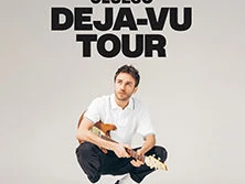 Musiker Clueso in gehockter Pose mit Gitarre vor grauem Hintergrund, Schriftzug: Clueso Déjà-vu Tour.