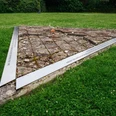 Mahnmal ehemaliges KZ Niederhagen Dreieckiges Mahnmal aus Steinplatten auf Rasen des ehemaligen KZ Niederhagen symbolisiert das Gedenken.