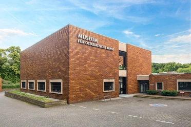 Gebäude des Museums für Ostasiatische Kunst in Köln, umgeben von Bäumen.