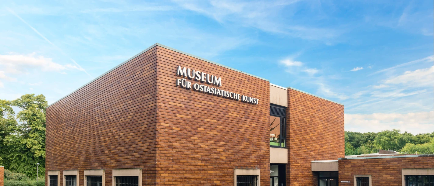 Gebäude des Museums für Ostasiatische Kunst in Köln, umgeben von Bäumen.
