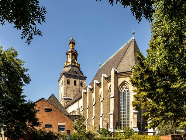 Saint Ursula St. Ursula's Church with its striking bell tower, surrounded by trees, under a clear sky.