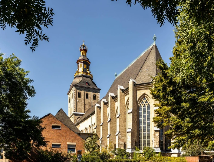Sankt Ursula Sankt Ursula Kirche mit markantem Glockenturm, umgeben von Bäumen, unter klarem Himmel.St. Ursula's Church with its striking bell tower, surrounded by trees, under a clear sky.