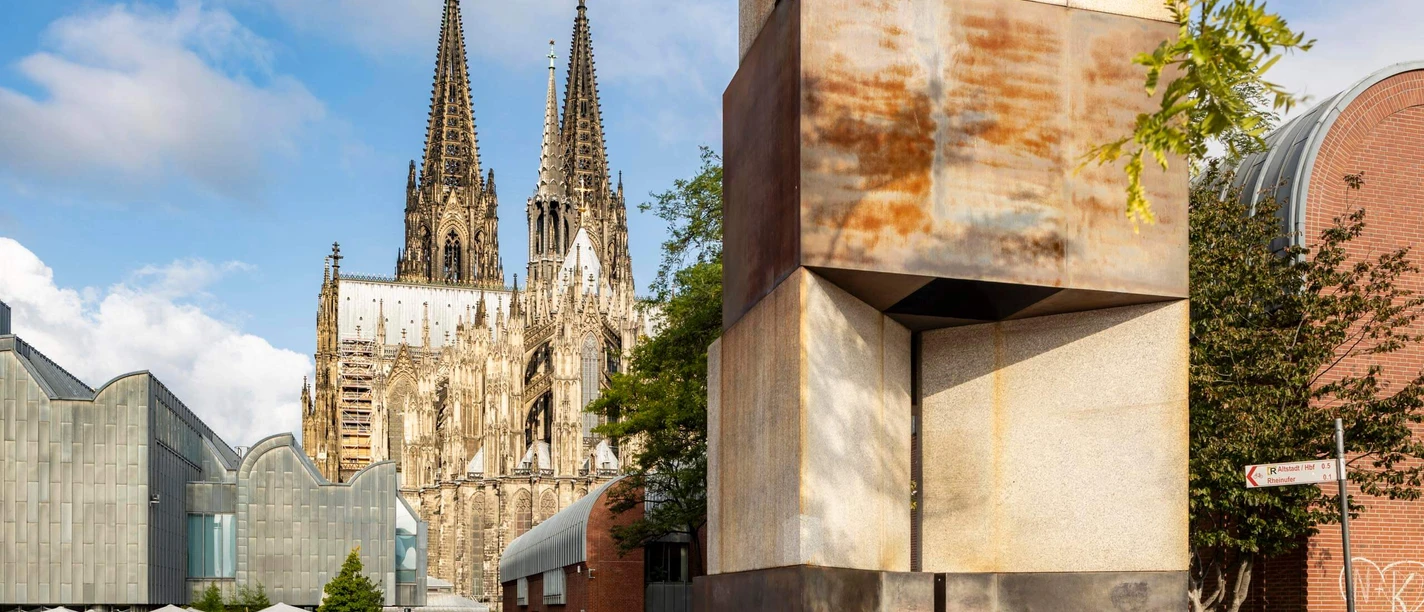 MAALOT Sculpture "MA'ALOT" by Dani Karavan in front of Cologne Cathedral under a sunny sky.