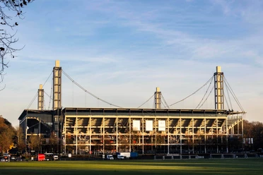 RheinEnergieSTADION RheinEnergieSTADION in Köln, umgeben von Bäumen und grüner Rasenfläche.