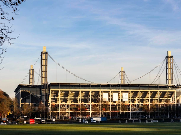 RheinEnergieSTADION RheinEnergieSTADION in Köln, umgeben von Bäumen und grüner Rasenfläche.