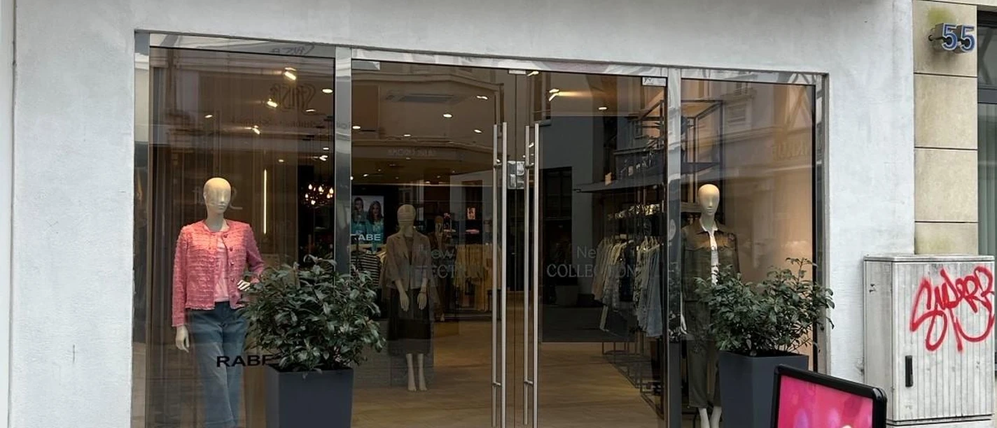 Eingang des RABE Stores mit Schaufenstern, Modepuppen und Werbeaufsteller