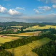 lage-hoerster-egge-teutoburger-wald-tourismus-d-ketz-005-jpg.jpg Panorama des Teutoburger Waldes mit weiten Feldern, sanften Hügeln und bewaldeten Abschnitten.