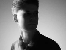 Schwarz-Weiß-Porträt eines nachdenklichen jungen Mannes mit Blick zur Seite.