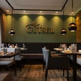 Innenansicht im Restaurant Gütsel Gemütliches Restaurant Gütsel mit stilvoller Beleuchtung, modernem Interieur und Apfel-Wanddekor.