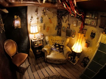 Escape-Room Bad Oeynhausen II Ein gemütlicher Raum mit Dekorationen, antiken Möbeln und warmem Licht lädt zum Entdecken ein.