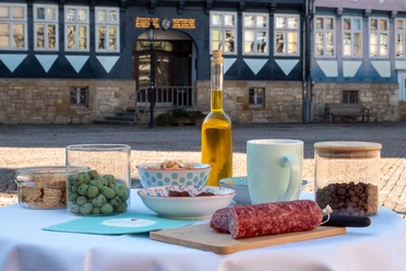 Genusspfade Gedeckter Tisch mit Leckereien zum Probieren auf dem sonnigen Stadtmarkt.