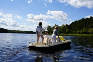 _A7_4054.JPG Ein Tretboot mit drei fröhlichen Personen gleitet über das Ottermeer unter einem blauen, mit Wolken gesprenkelten Himmel.