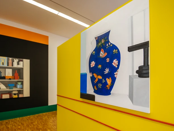 Dans la salle d'exposition de la Galerie d'art contemporain, on peut voir au premier plan, à droite, une peinture représentant un vase de fleurs multicolores, et au second plan, à gauche, une autre peinture représentant une étagère remplie, art, culture, maison d'exposition