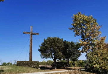 mahnkreuz_stahle_dueker.jpg Großes Holzkreuz auf Bergrücken mit Baumbestand an rechter Seite