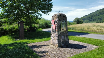 oestlichster_winkel_nrw_stahle_struck.jpg Steinerner Infopunkt am Rand eines Radweges mit angebrachtem Wappen der Ortschaft und Silhouette des Corveyer Westwerkes