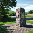 oestlichster_winkel_nrw_stahle_struck.jpg Steinerner Infopunkt am Rand eines Radweges mit angebrachtem Wappen der Ortschaft und Silhouette des Corveyer WestwerkesStone information point on the edge of a cycle path with the town's coat of arms and silhouette of the Corvey westwork