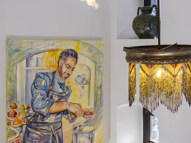Restaurant Der vierte König Painting of chef and owner Jaspreet Dhaliwal-Wilmes preparing a dish hangs in the interior of the restaurant