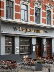 Lapidarium Ein Eingang des Lapidarium in Köln mit roten Ziegeln und blauen Fensterrahmen.