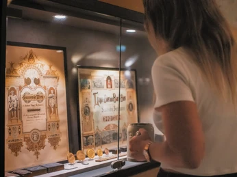 Bier, Keller, Brauerei, ©Spieker Fotografie (1).JPG Frau mit Bierkrug vor einer Vitrinenscheibe.