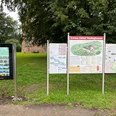 Infoterminal am Schloss Erbhof Infoterminal und Schautafeln vor Schloss Erbhof, umgeben von grünen Bäumen und historischen Mauern.